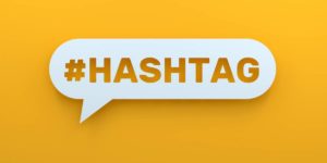 A white speech bubble with the word "#HASHTAG" in bold orange letters against a bright yellow background.